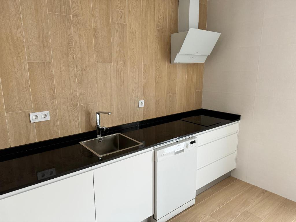 桑坦德Alojamientos Robustiana的厨房配有白色橱柜和水槽