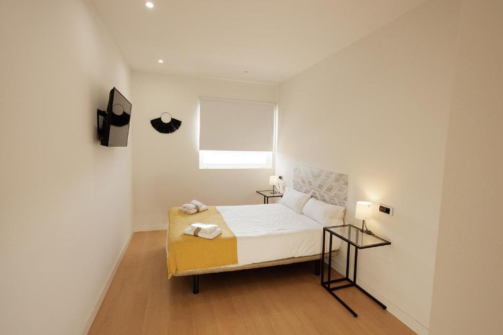 比亚努夫拉Habitación Villanubla的一间小卧室,配有一张床和两张桌子