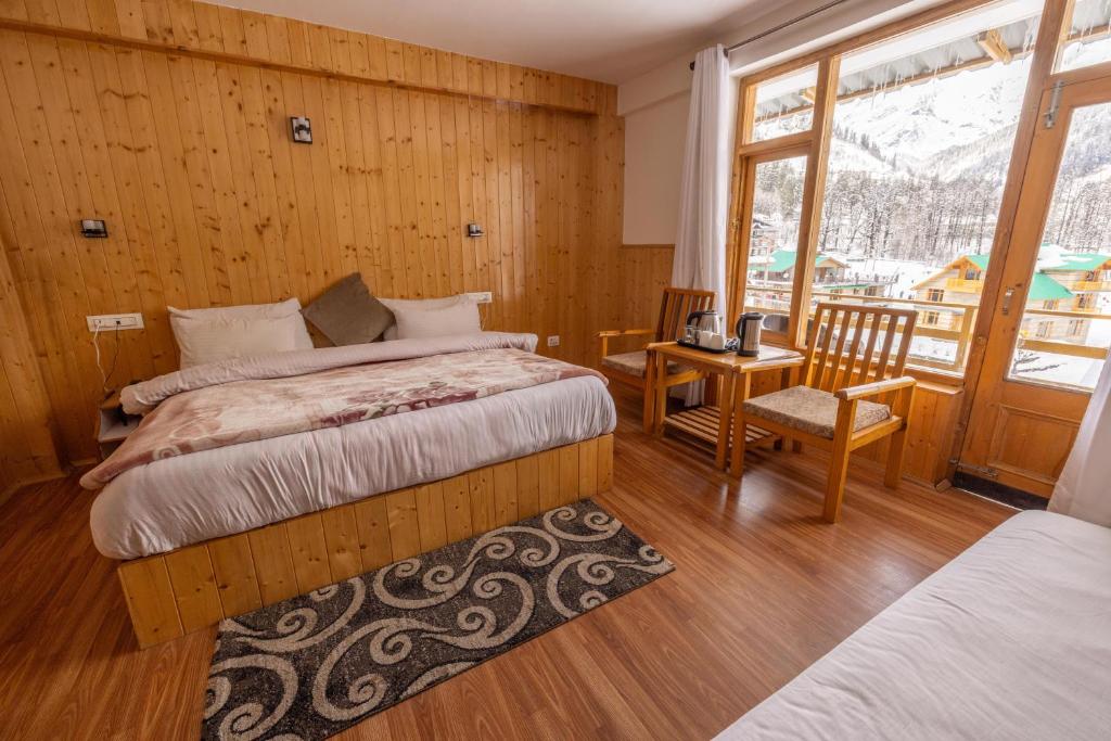马拉里Adventure Valley的一间卧室配有两张床和一张桌子及椅子