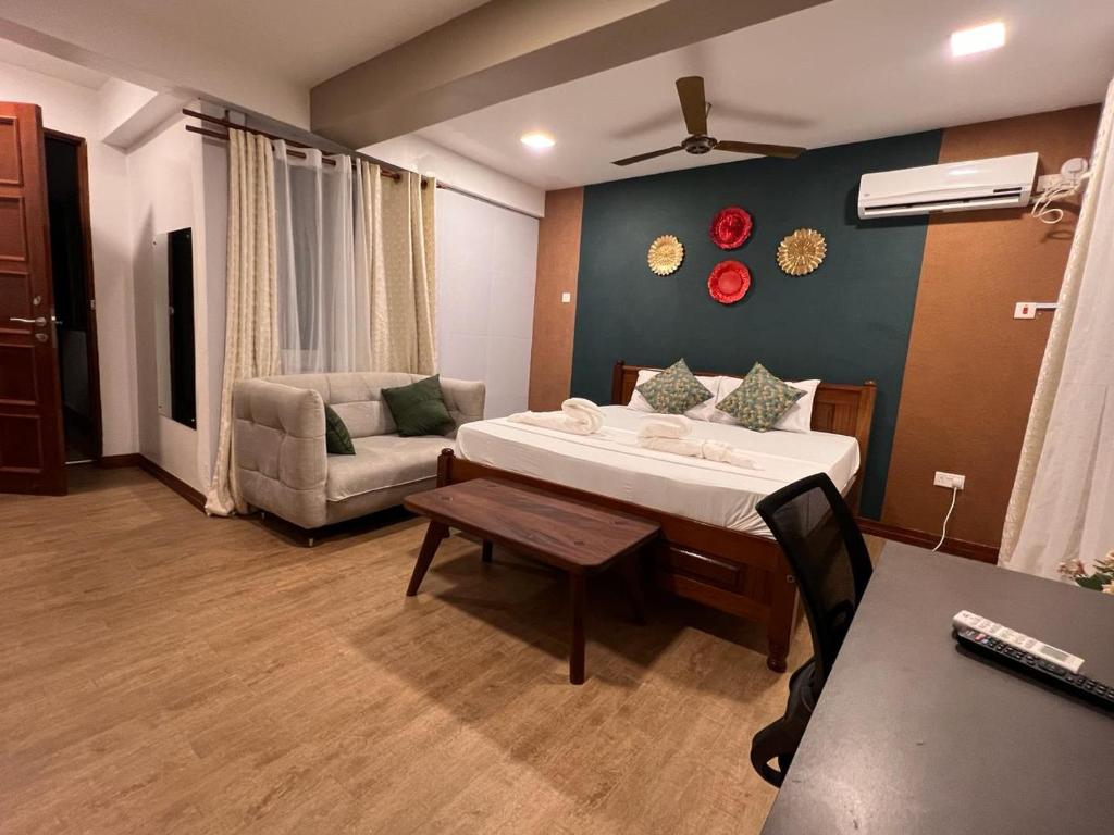 蒙巴萨SPACIOUS STUDIO IN NYALI with AC opposite voyager resort RITZ APARTMENT的一间卧室配有一张床、一张沙发和一张桌子