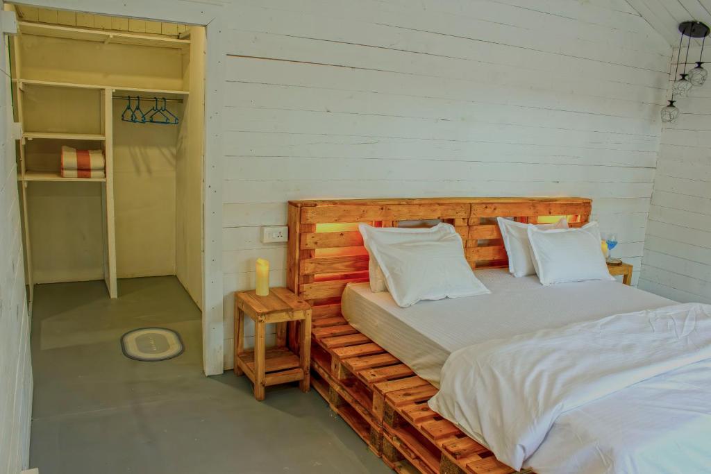 卡纳科纳The Pearl Beach Resort的一间卧室配有带白色枕头的木床