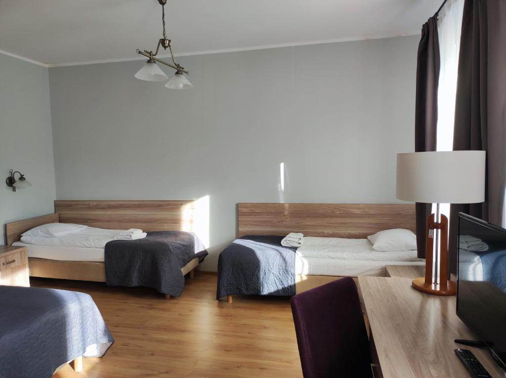 米兹多洛杰Polonia的客房设有两张床和一张带台灯的桌子。