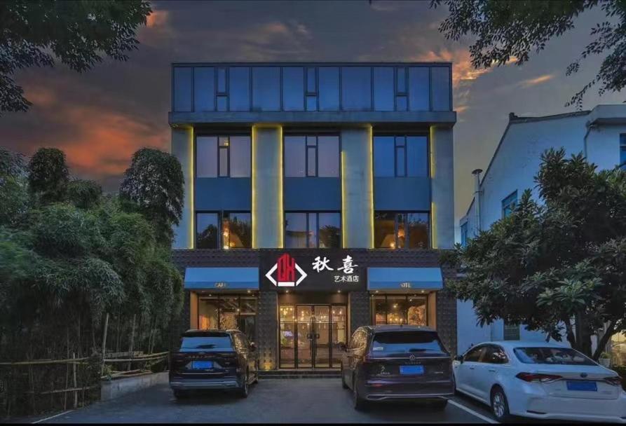 桐乡乌镇秋喜艺术酒店的两辆车停在大楼前的建筑物