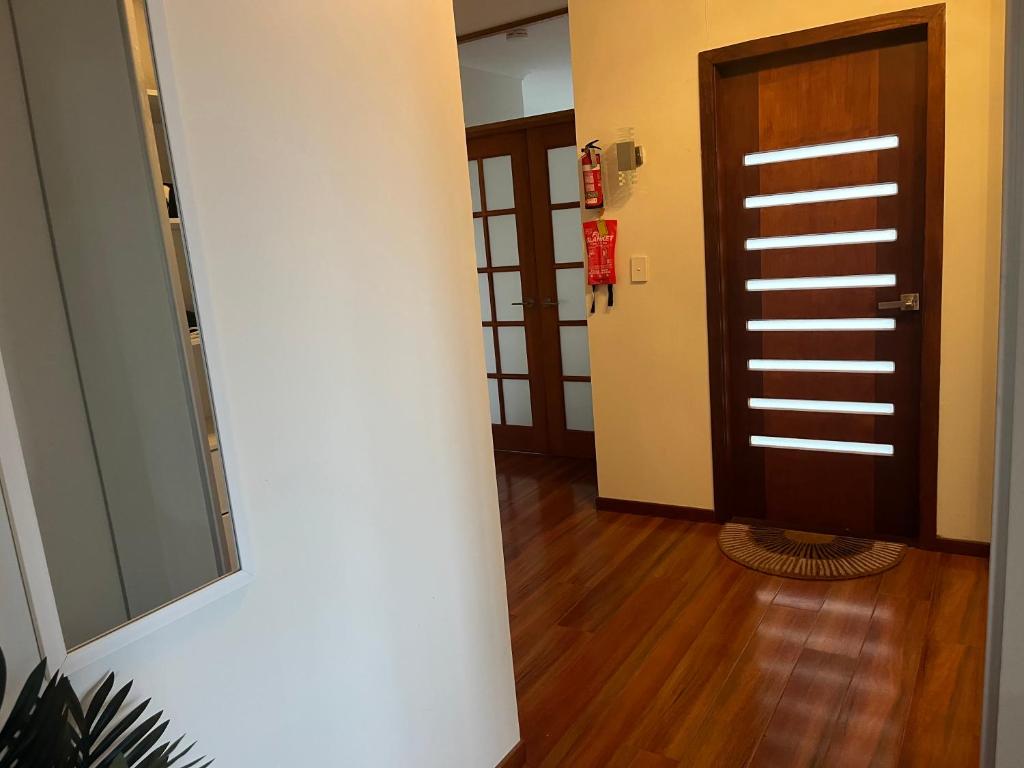 棕榈滩Palm beach Sydney, Modern home with water view的走廊上设有门,铺有木地板