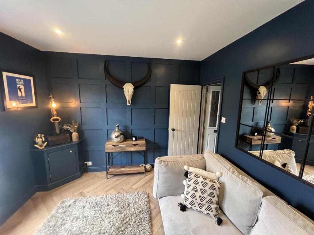 吉尔福德Remarkable 3-Bed House in the centre of Guildford的客厅拥有蓝色的墙壁和沙发