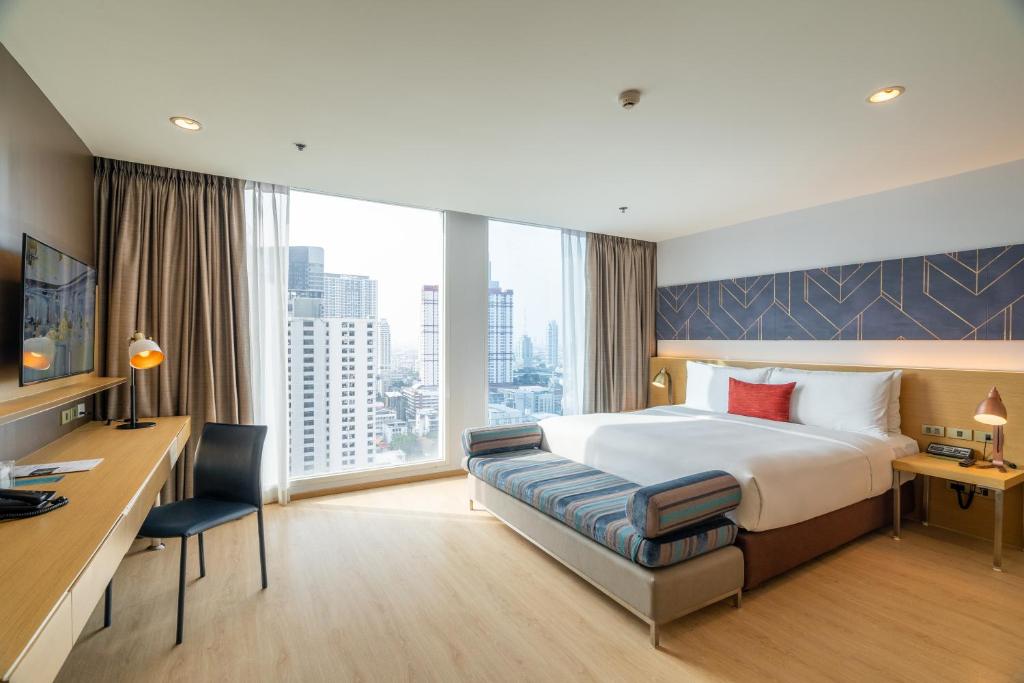 曼谷VELA Dhi GLOW Pratunam的酒店客房设有一张大床和一张书桌。