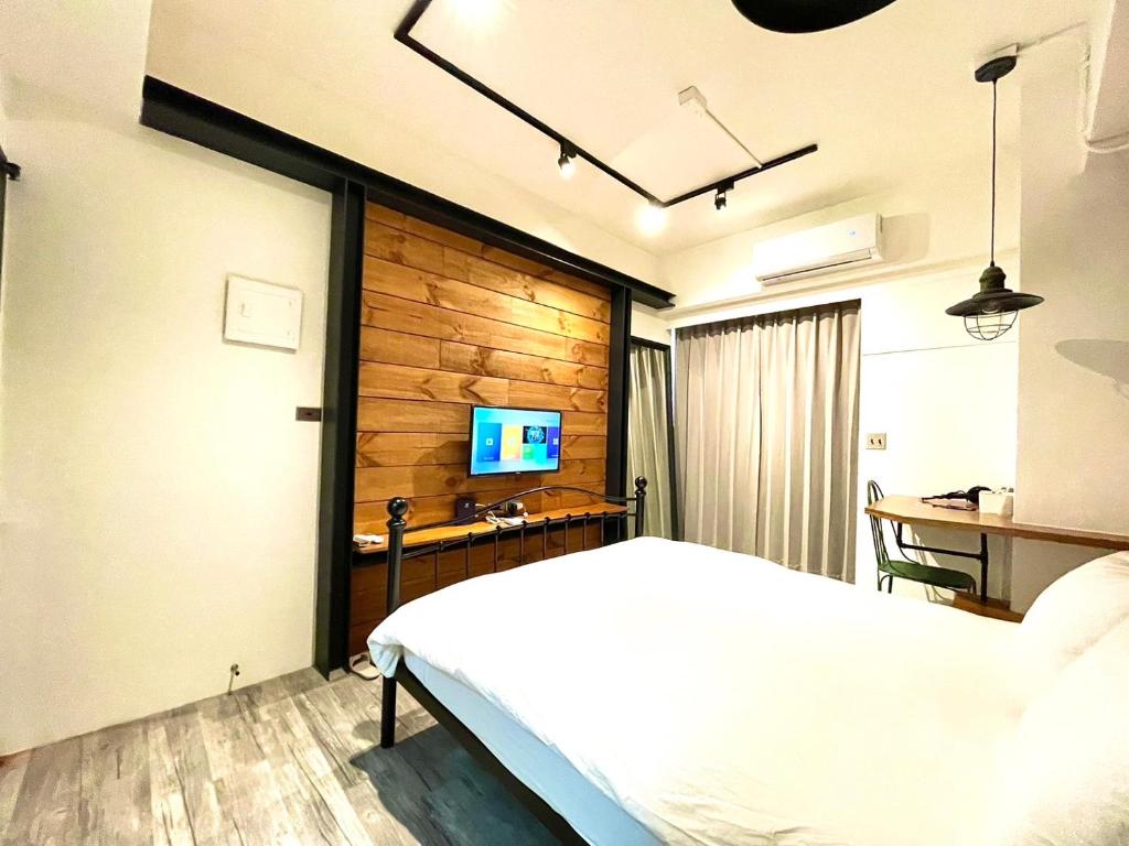 台中市逢甲沐蓁的卧室配有白色的床和电视。