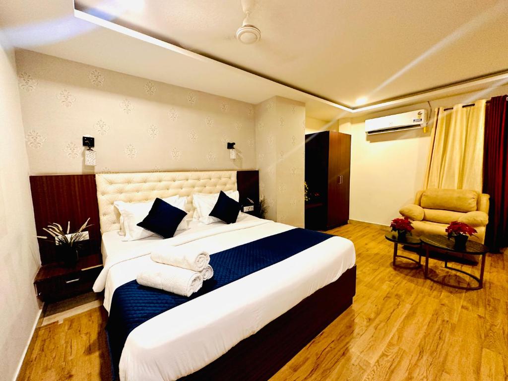 海得拉巴Rainbow Tower Hotel Airport Road的酒店客房带一张大床和一把椅子