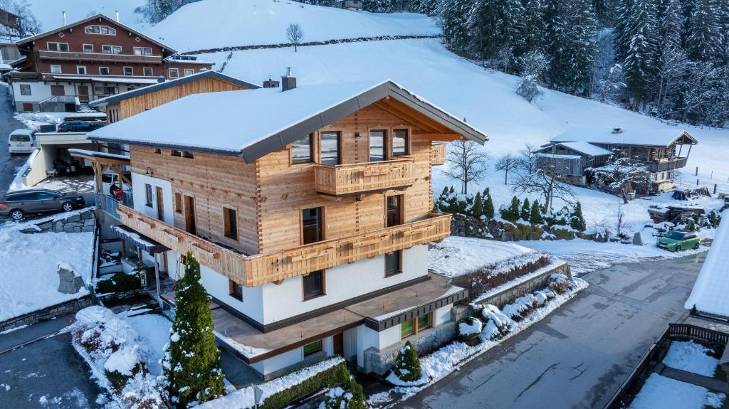 维尔德科格尔山麓布兰贝格Ferienwohnung Gipfelreich的屋顶上积雪的木屋