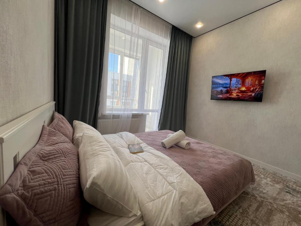 阿斯塔纳Уютная квартира в городе Астана, возле Барыс арена的一间卧室设有一张大床和窗户