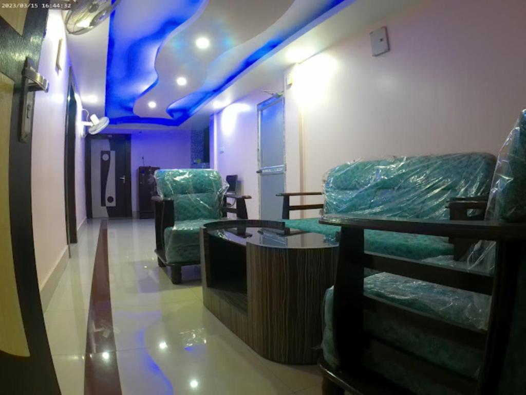 阿加尔塔拉Roop Amrit Guest House , Agartala的一间设有椅子和桌子的房间和蓝色的天花板