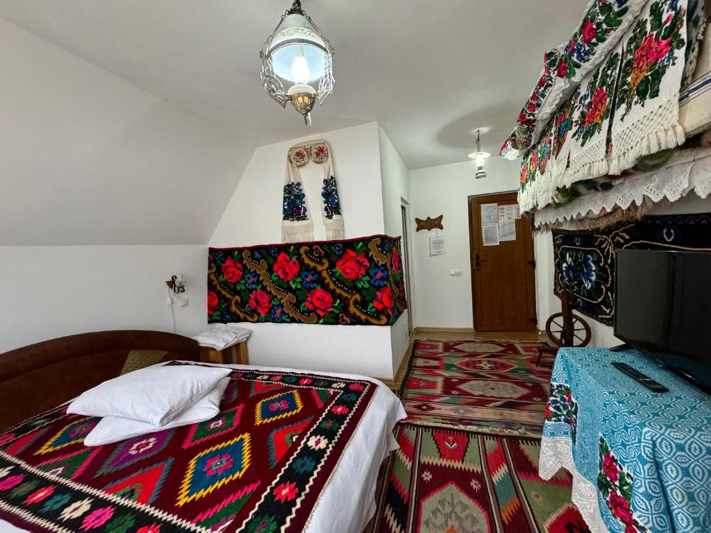 DeseştiPensiunea Irina Maramureș的一间卧室配有一张带彩色毯子的床