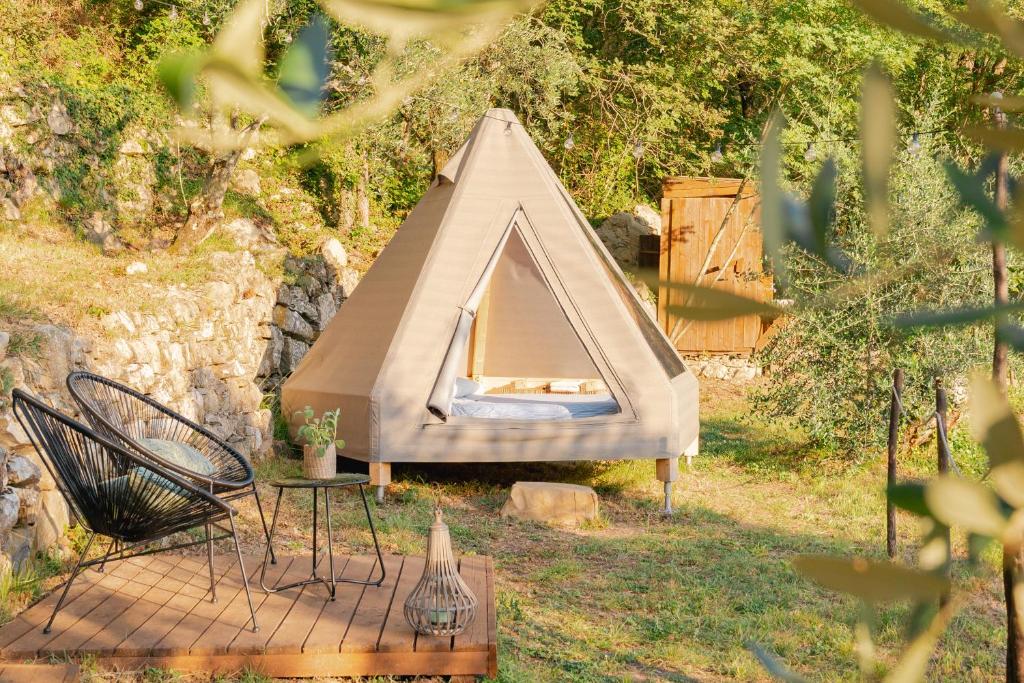 ChiusanicoTipì - Glamping Experience的庭院里的帐篷,配有桌椅