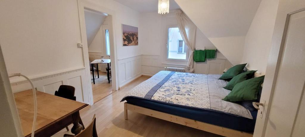 圣加仑2 Zimmer Zentral-ruhig mit Flair Gertrud Schlössli的一间卧室配有一张带绿色枕头的床和一张桌子