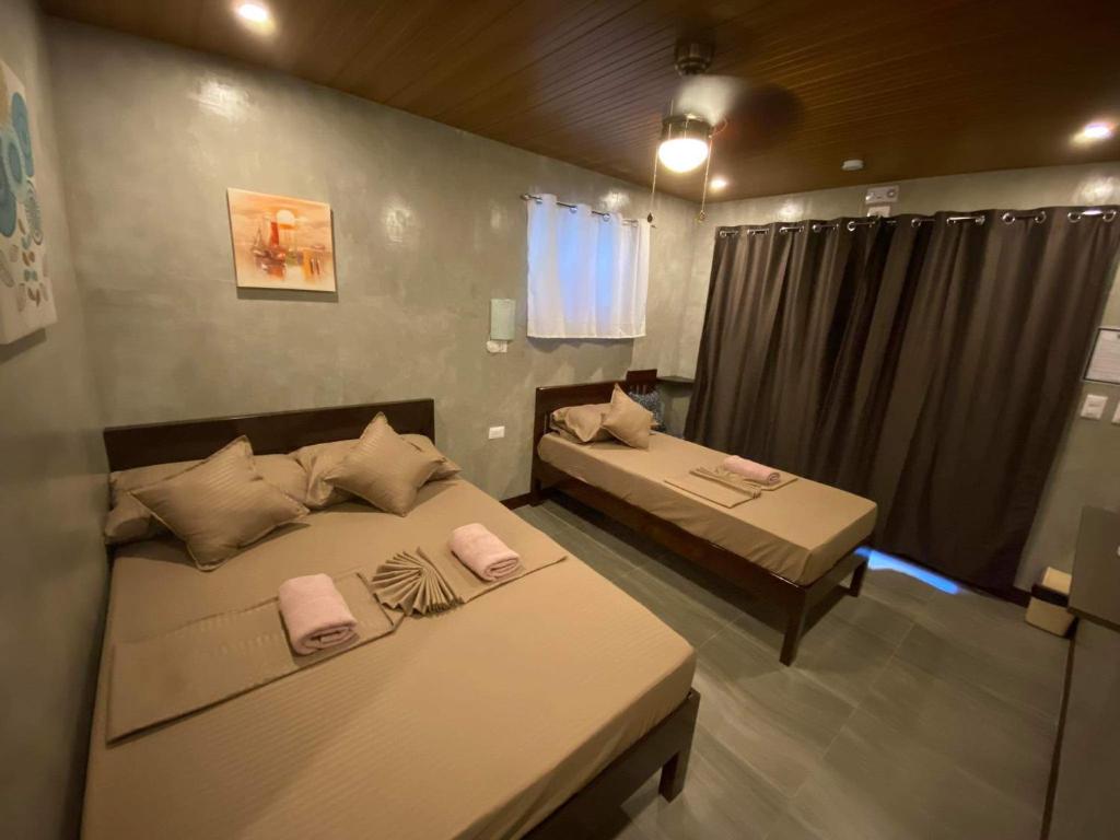 公主港Wilnags Inn Puerto Princesa near airport的带2张床的客房,位于带窗户的房间内