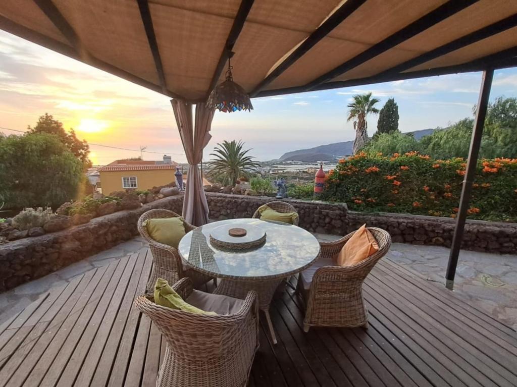 洛斯·亚诺斯·德·阿里丹Casa Mosaico, sunset and garden的木制甲板上配有桌椅的天井