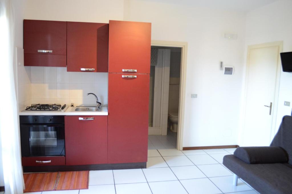 马西亚娜马里纳勒斯皮亚格公寓的一间带红色橱柜和炉灶的厨房