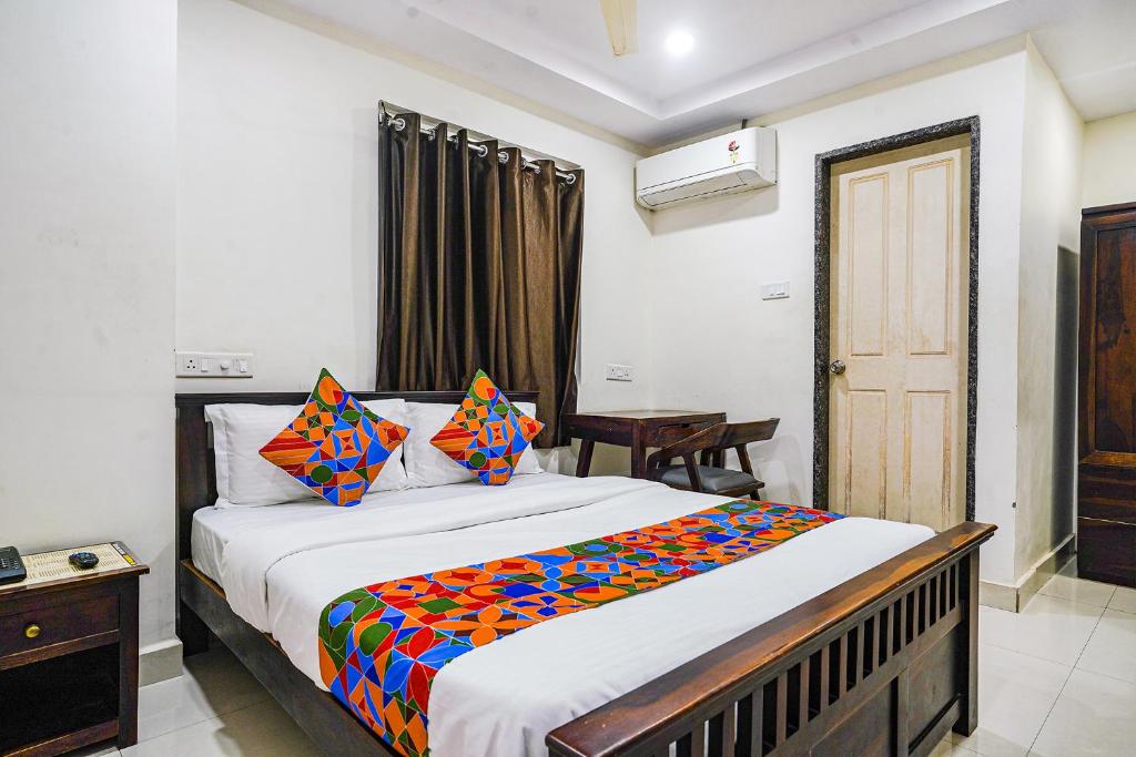 海得拉巴FabHotel Hamsa The Right Choice的一间卧室配有一张带彩色毯子的床