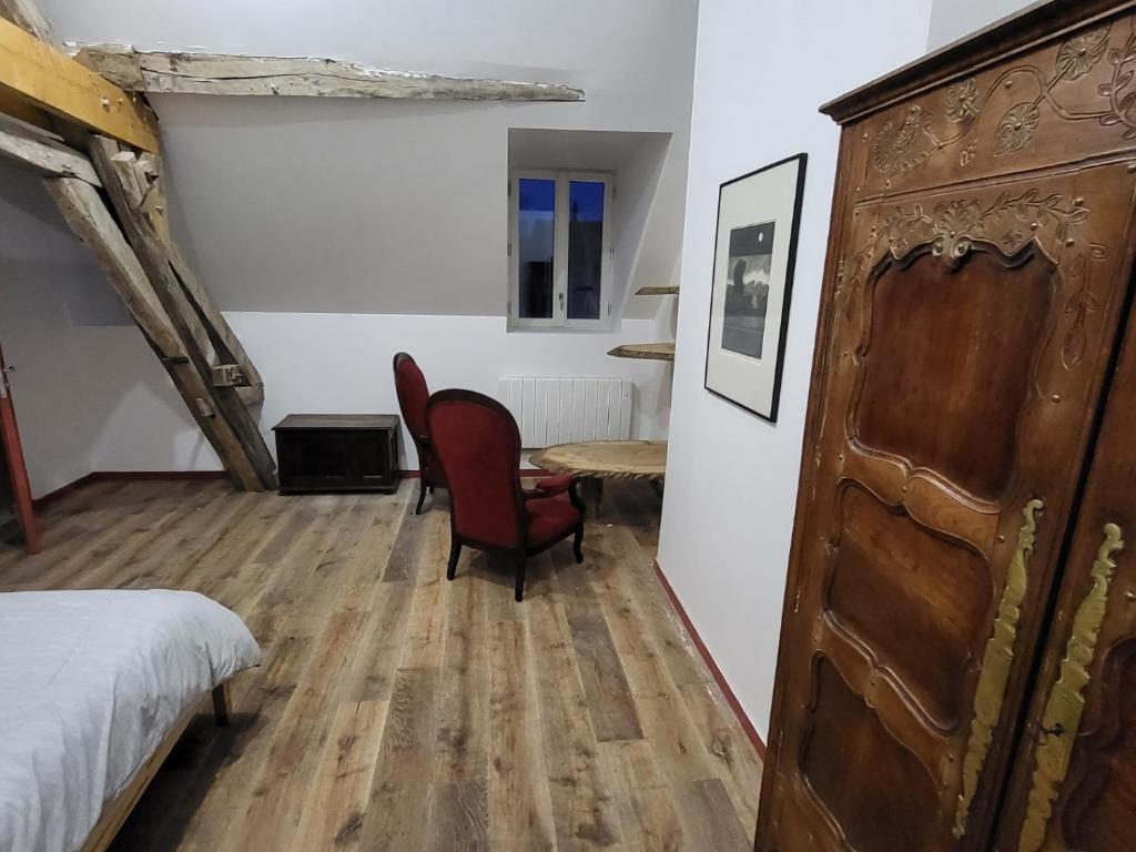 爱斯科利夫-圣卡米Les Oiseaux de Passage的卧室配有一张床和一张桌子及椅子