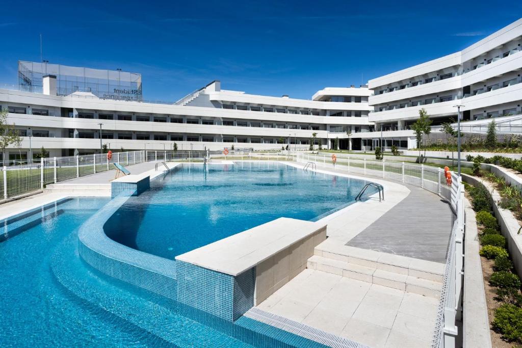波苏埃洛-德阿拉尔孔Student Experience Madrid Pozuelo - Luxury Hostel的大楼前的大型游泳池
