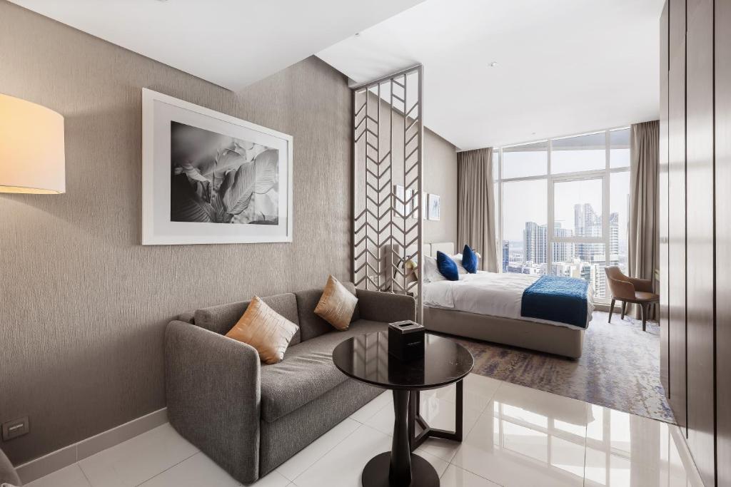 迪拜New Aparthotel Prive的酒店客房设有一张沙发和一张床