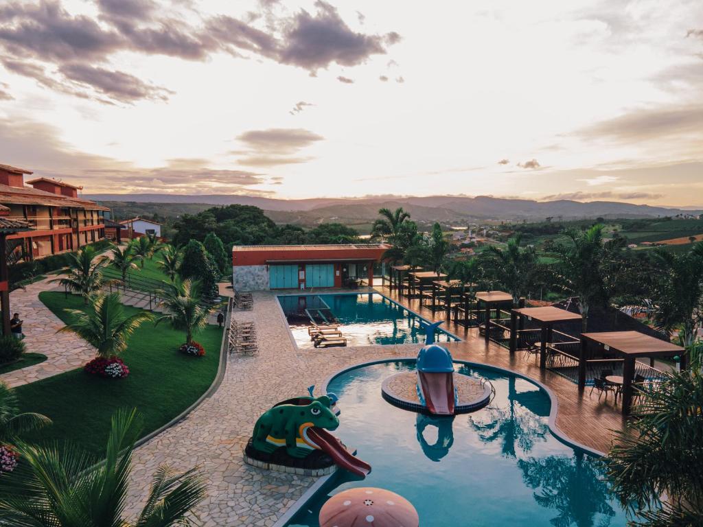 卡皮托利乌Escarpas resort的一个带桌椅的游泳池的度假酒店