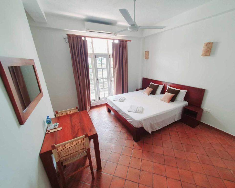 拉维尼亚山山湾宾馆 的一间卧室配有一张床、一张桌子和一个窗户。