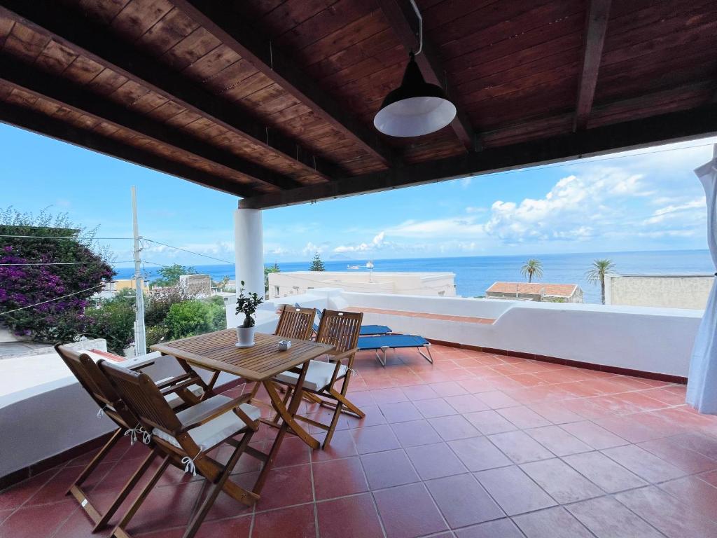 圣马里纳萨利纳Villa Margherita - Appartamenti a due passi dal corso di Santa Marina Salina a 100 mt dalla spiaggia的一个带桌椅的庭院和大海