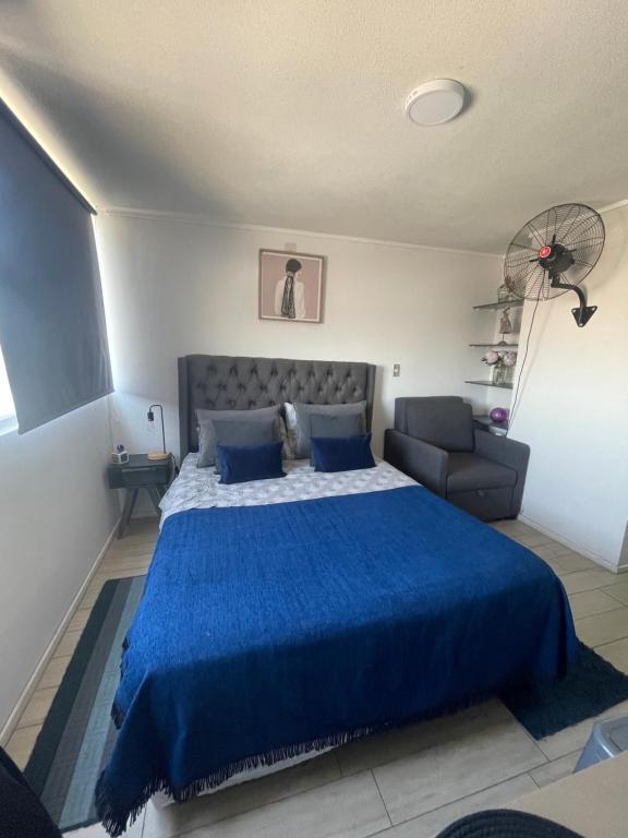 圣地亚哥Departamento en Santiago centro cerca de movistar arena, Caupolican的一间卧室配有蓝色的床和沙发