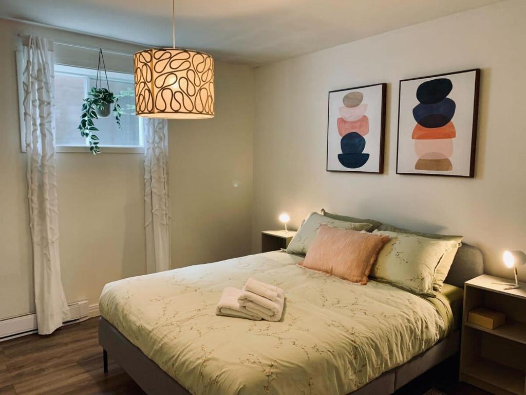 哈利法克斯Stylish Apt #1, Central Location的一间卧室配有一张带吊灯的床