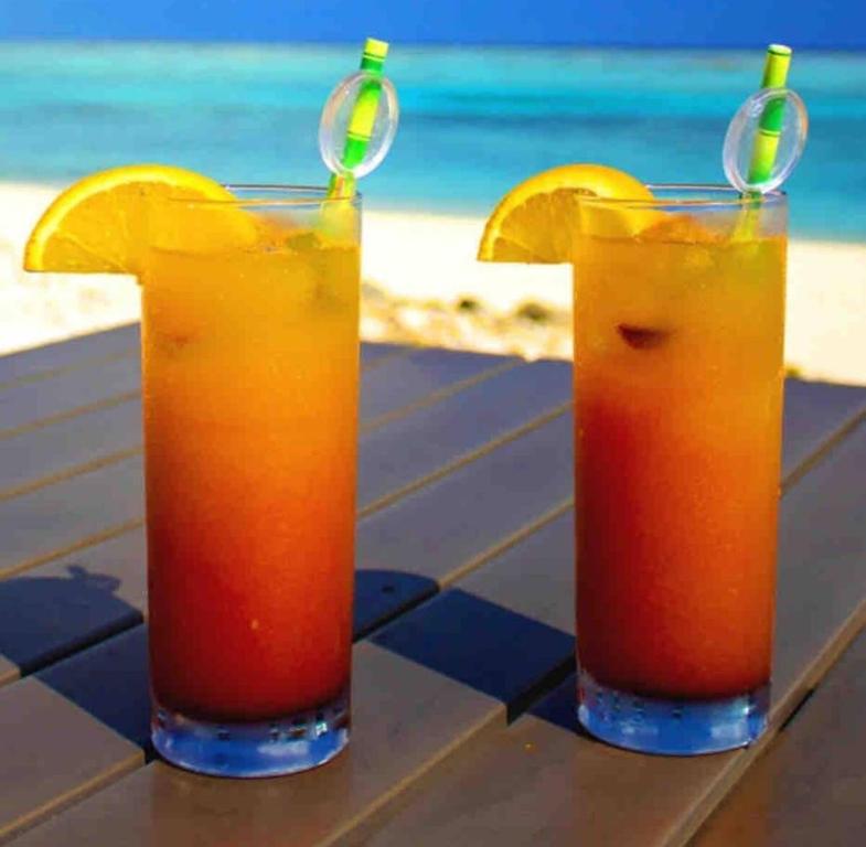 古斯塔维亚Annoncé supprimée的海滩附近的桌子上放两杯橙汁