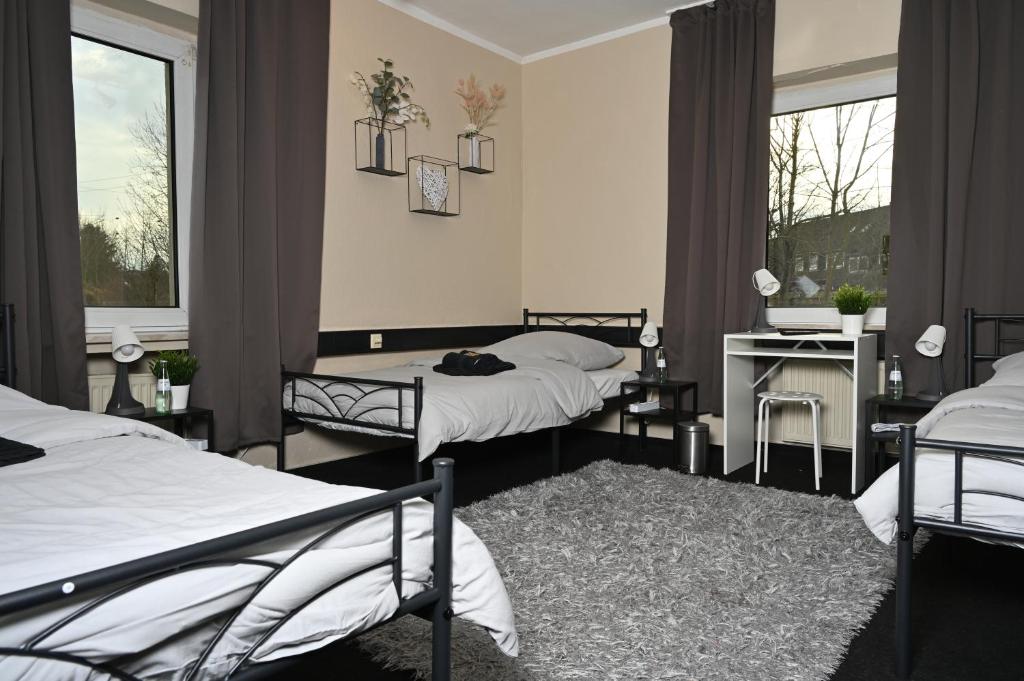 埃森Pott Hostel - Zimmervermietung的客房设有两张床和一张书桌