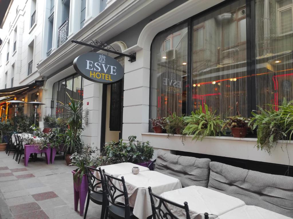 伊斯坦布尔Hotel Esve Istanbul的大楼前设有桌椅的餐厅