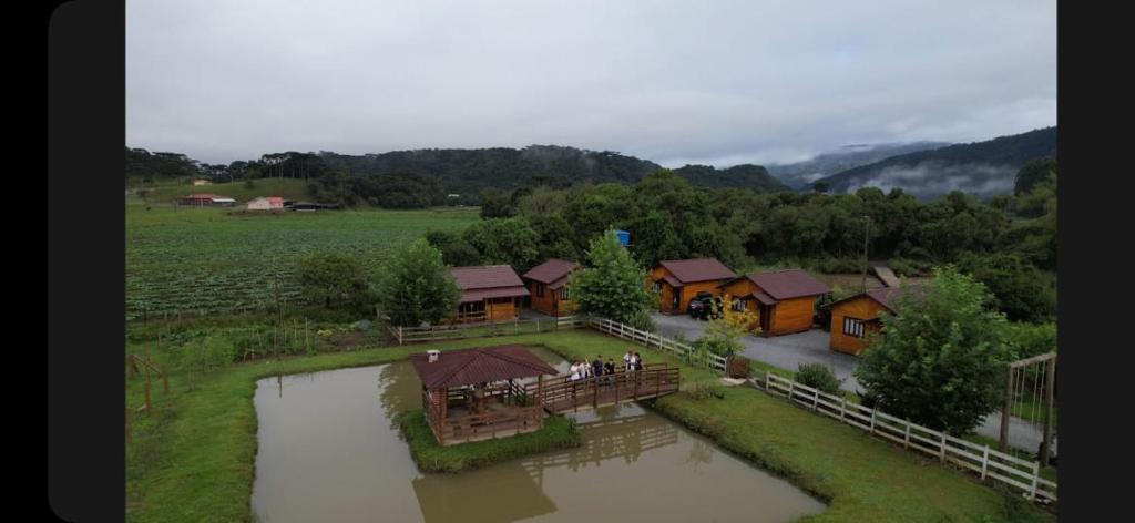 乌鲁比西Pousada rio canoas的享有房子和河流的空中景色