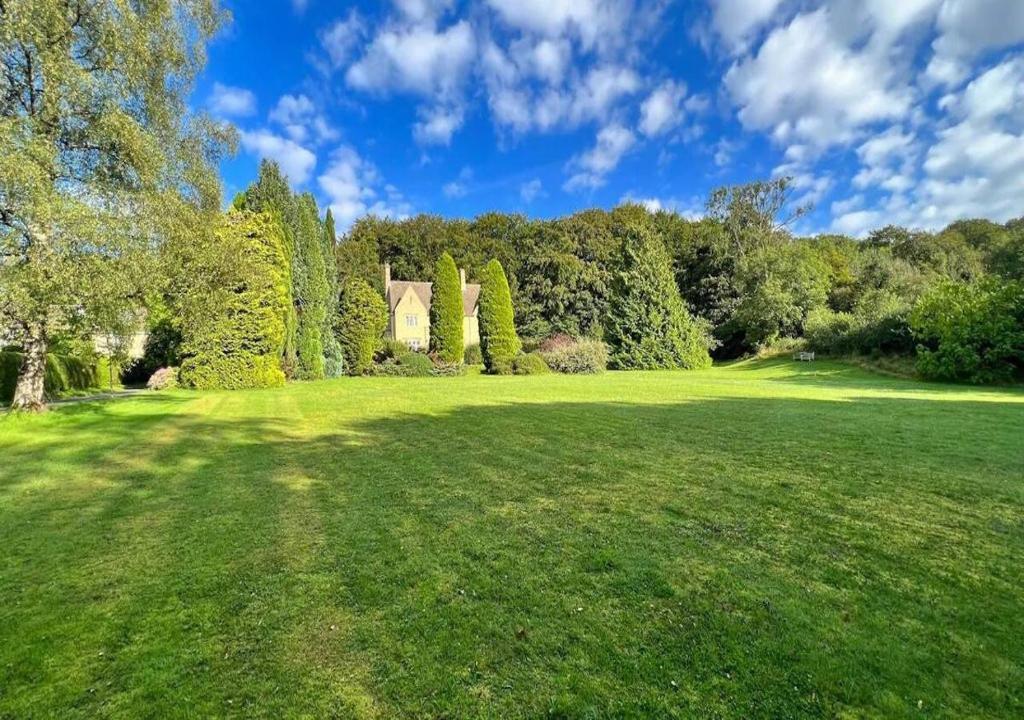 佩恩斯威克Perfect Cotswold Home with vast stunning Ground's的一片绿地,有房子和树木