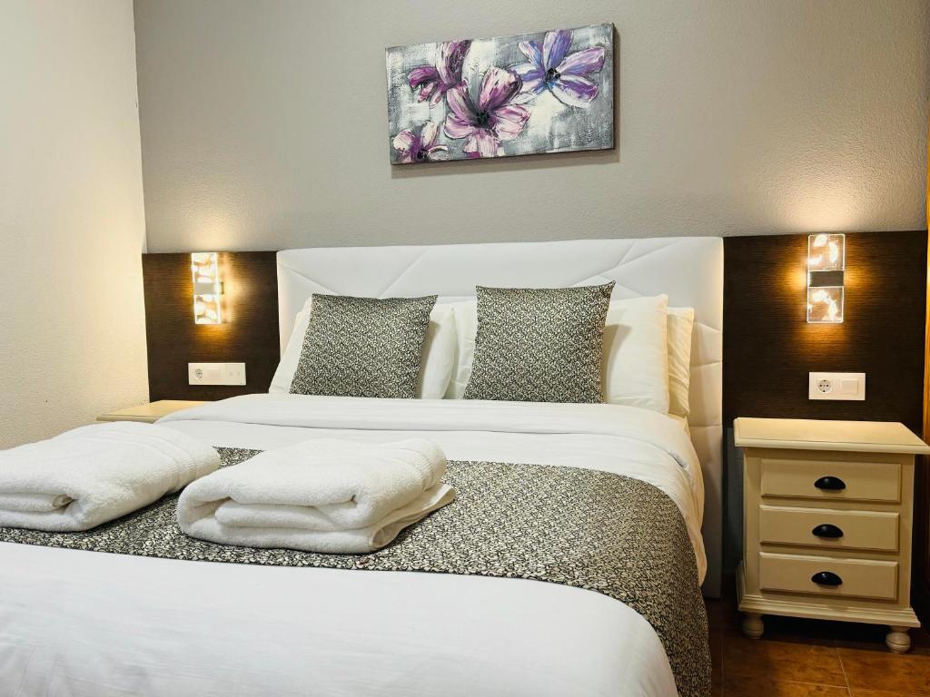 Barajas de MeloBallestar Hotel Bar & Grill的一间卧室配有两张带白色枕头的床