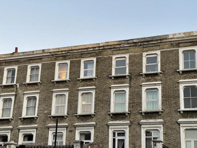 伦敦RSB Inn London的一座大型砖砌建筑,设有白色窗户
