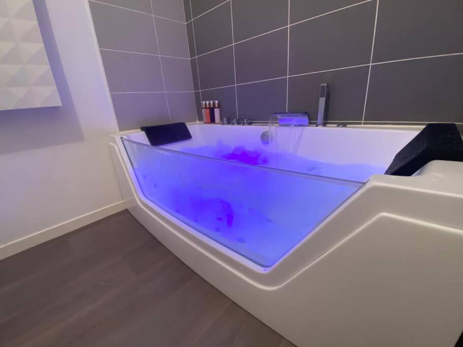 沃昂夫兰Appartement 65m2 avec terrasse privé & jacuzzi的浴室内设有一个紫色染料浴缸