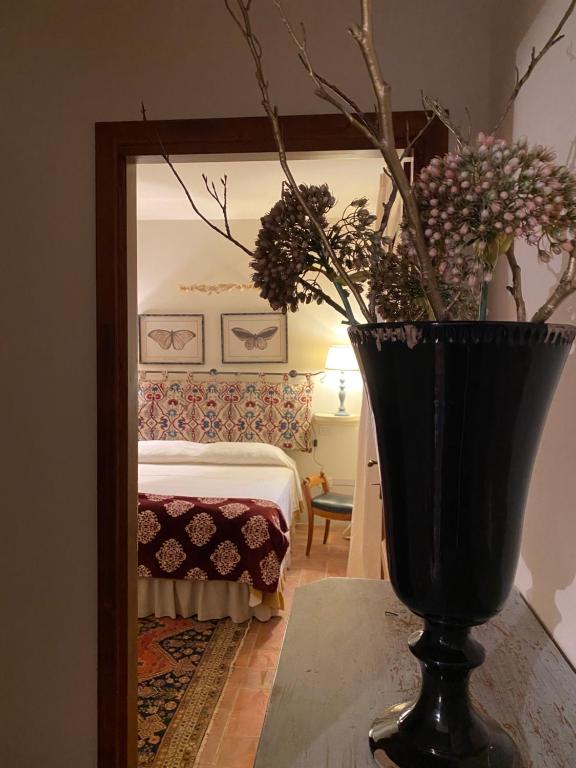 兰波雷基奥Il Borghetto Andrea Tafi的镜子前有鲜花的黑色花瓶