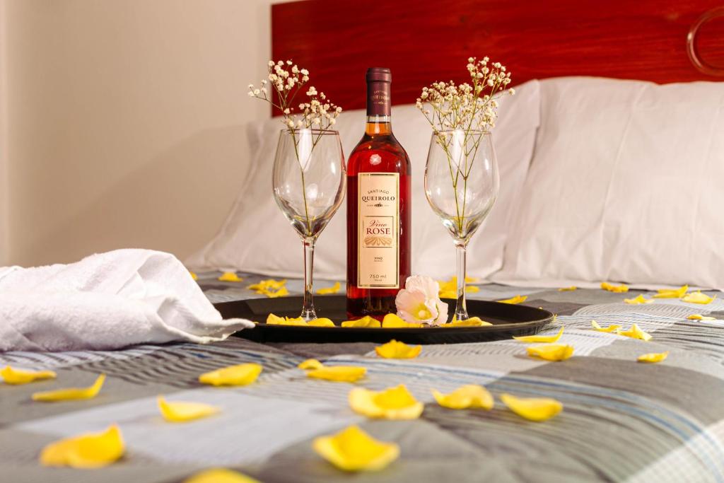 瓦努科YURAQ WASI Hotel/Restobar的桌子上放有一瓶葡萄酒和两杯酒