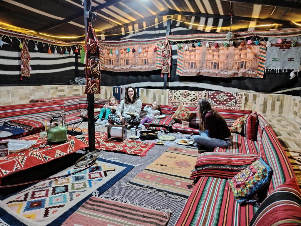 瓦迪穆萨Petra Magic Guest House的一群人坐在地毯上