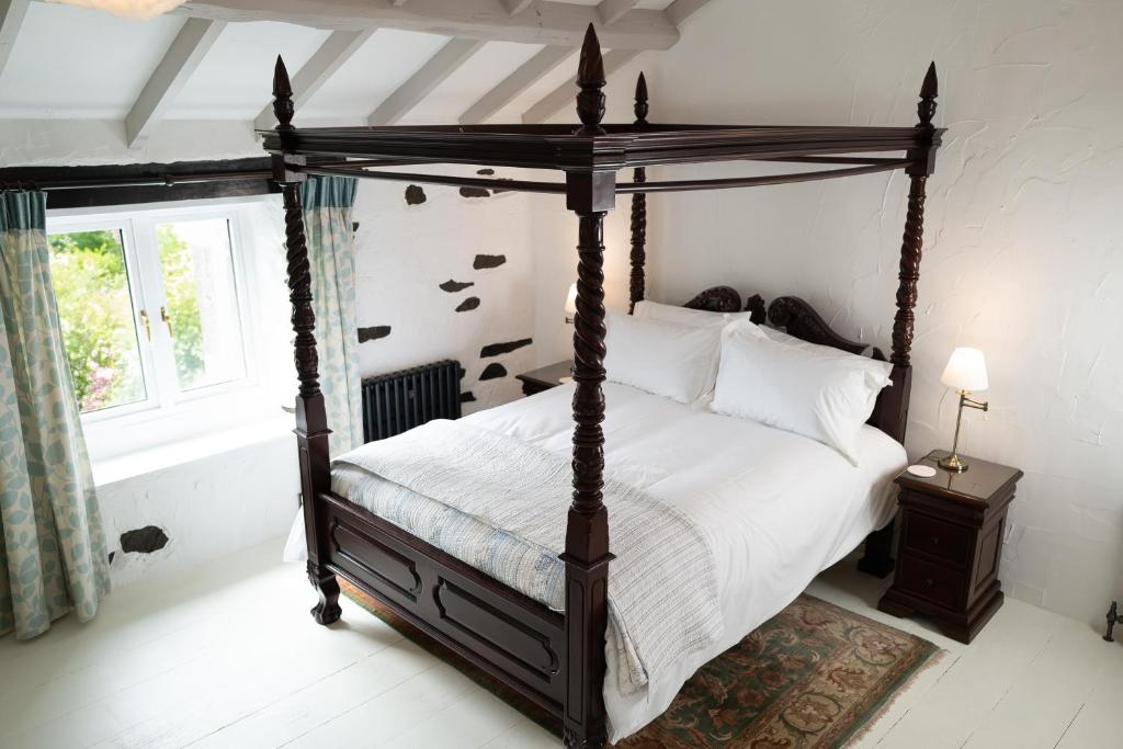 阿尔弗斯顿Bluebell cottage的一间卧室设有天蓬床和窗户。