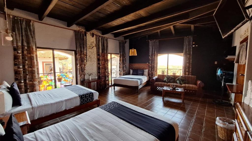 库埃察兰德尔普罗格雷索Posada La Plazuela的一间带两张床的卧室和一间带沙发的客厅