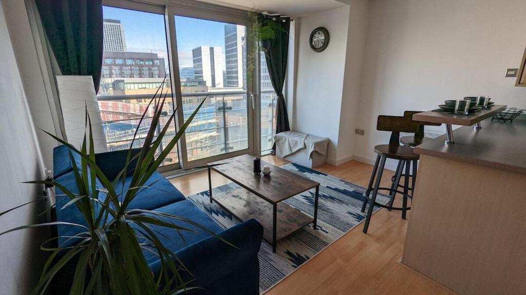 利兹Excellent Leeds City Centre 1 Bedroom Apartment的客厅设有蓝色的沙发和大窗户