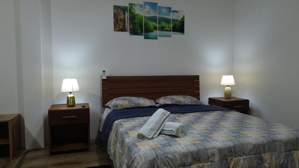 阿亚姆佩ROOM AYAMPE - La Casa de Eros的一间卧室配有一张带2个床头柜和2盏灯的床。