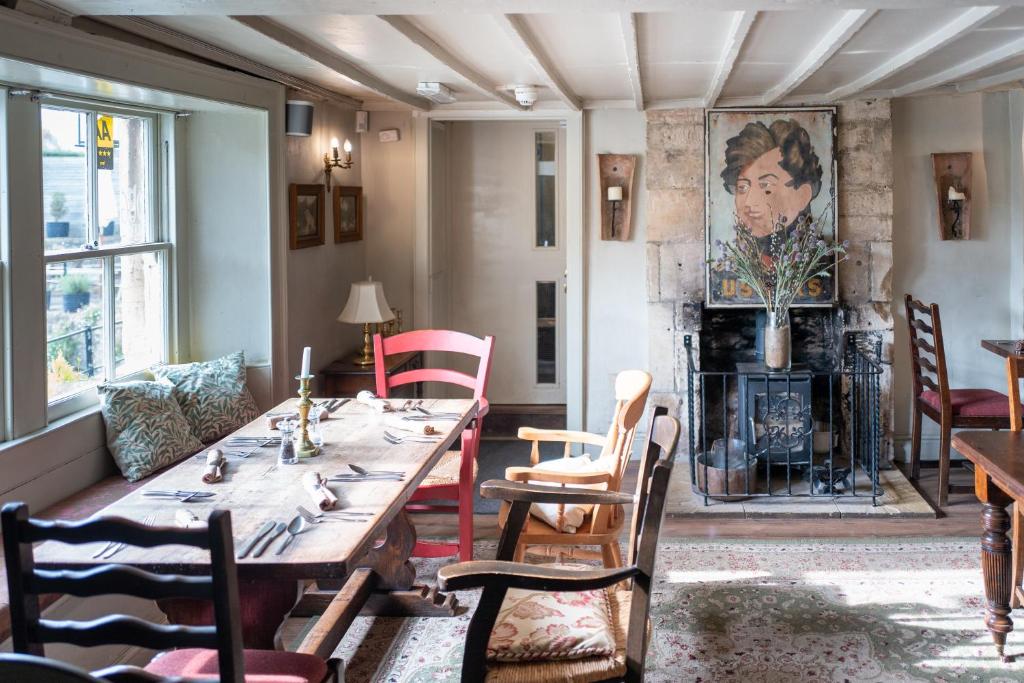 埃文河畔布拉德福The George的一间带桌椅和壁炉的用餐室