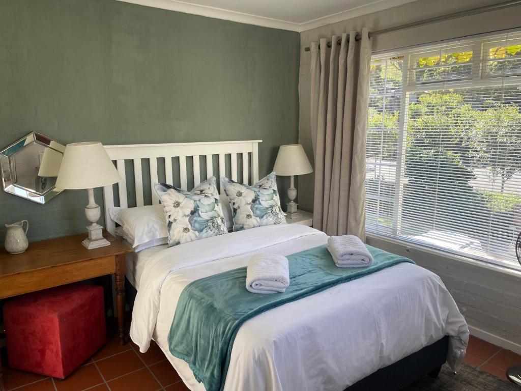 赫曼努斯Joy@Grotto Beach, Hermanus的一间卧室配有一张床,上面有两条毛巾
