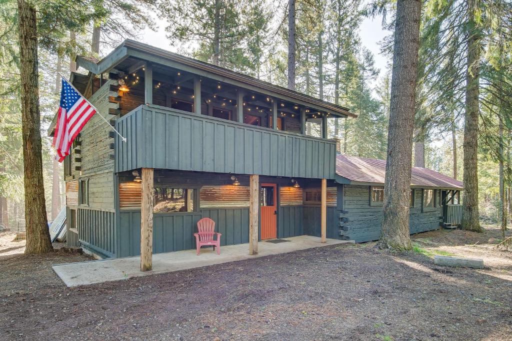 克拉马斯福尔斯Klamath Falls Cabin with Private Sauna and Fire Pit!的林中带美国国旗的房子
