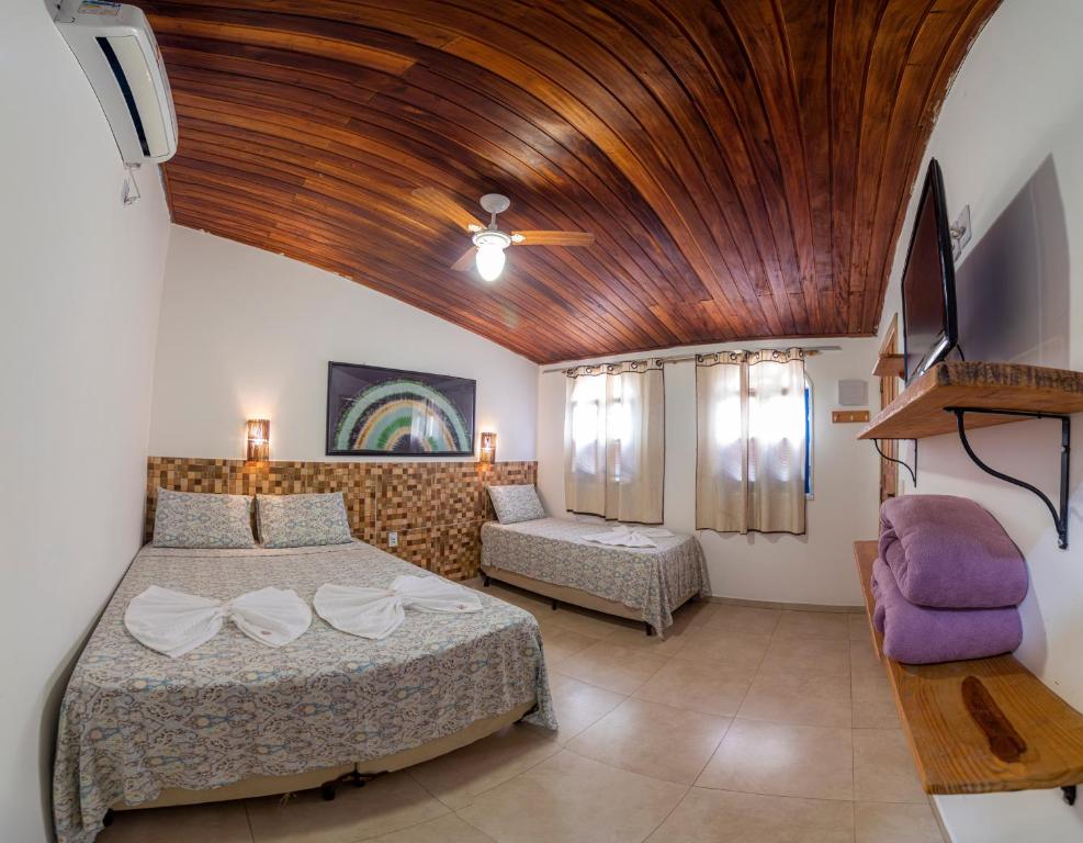 伦索伊斯Pousada Nativos Lençois的一间卧室设有一张大床和木制天花板