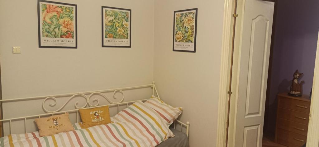 热舒夫Apartament VvGogh 4 pokoje的一间卧室配有一张带枕头的床,墙上挂有图片